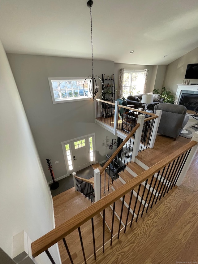 16 Catherine Dr, Wolcott, CT 06716 - staircase with a towering ceiling, a fireplace, wood finished floors, baseboards, and a chandelier