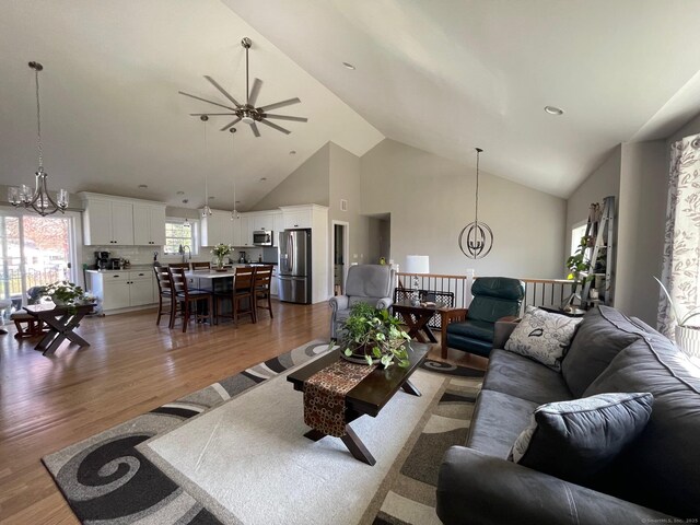 16 Catherine Dr, Wolcott, CT 06716 - living room with high vaulted ceiling, wood finished floors, and ceiling fan with notable chandelier