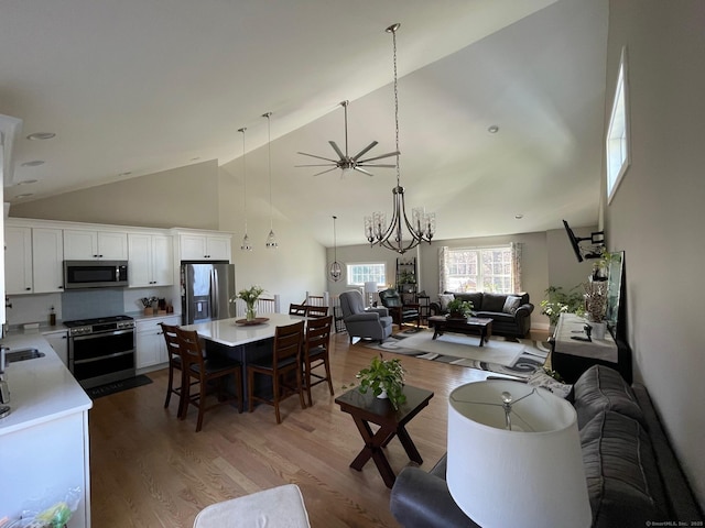 16 Catherine Dr, Wolcott, CT 06716 - living area featuring light wood-style floors, high vaulted ceiling, and ceiling fan with notable chandelier