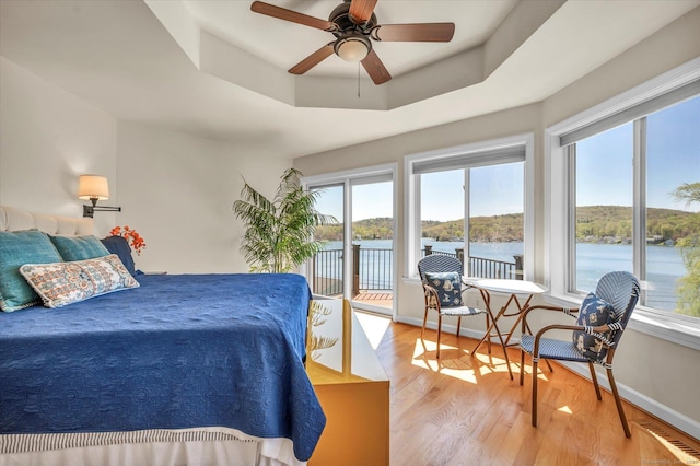 355 W Lake St, Winchester, CT 06098 - bedroom featuring ceiling fan, light wood-style floors, a water view, access to outside, and a tray ceiling