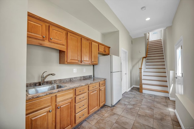 355 W Lake St, Winchester, CT 06098 - kitchen with a sink, baseboards, freestanding refrigerator, and brown cabinets