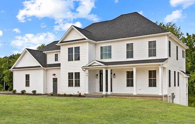 view of front of property featuring covered porch, a shingled roof, and a front yard