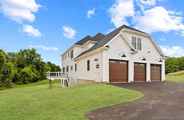 view of home's exterior with a lawn, stairs, a deck, and aphalt driveway