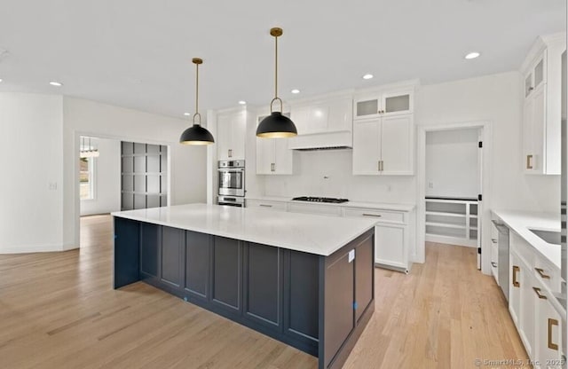 kitchen with white cabinets, black gas stovetop, and light wood-type flooring