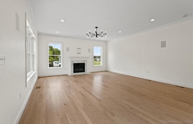 unfurnished living room with crown molding, a healthy amount of sunlight, and visible vents