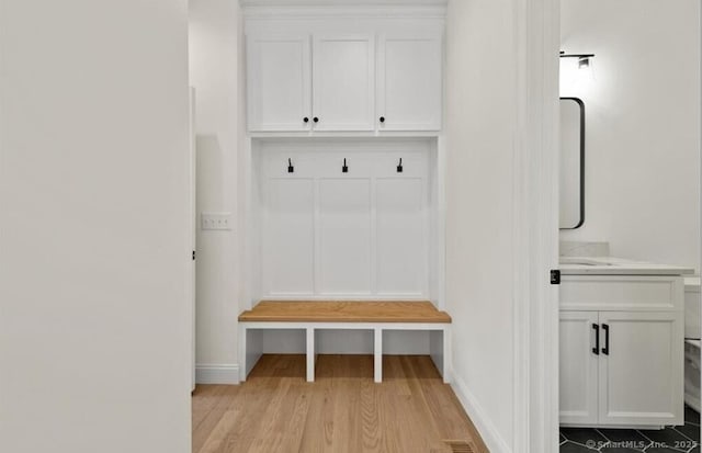 mudroom featuring baseboards and light wood-style flooring