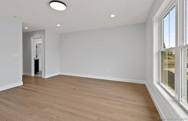 spare room featuring recessed lighting, baseboards, and light wood-style floors