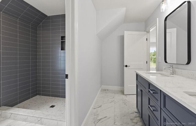 bathroom with a sink, double vanity, marble finish floor, baseboards, and tiled shower