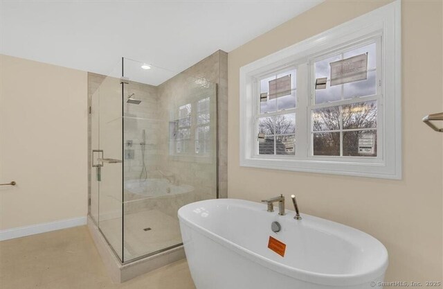 bathroom with a freestanding tub, a stall shower, and recessed lighting