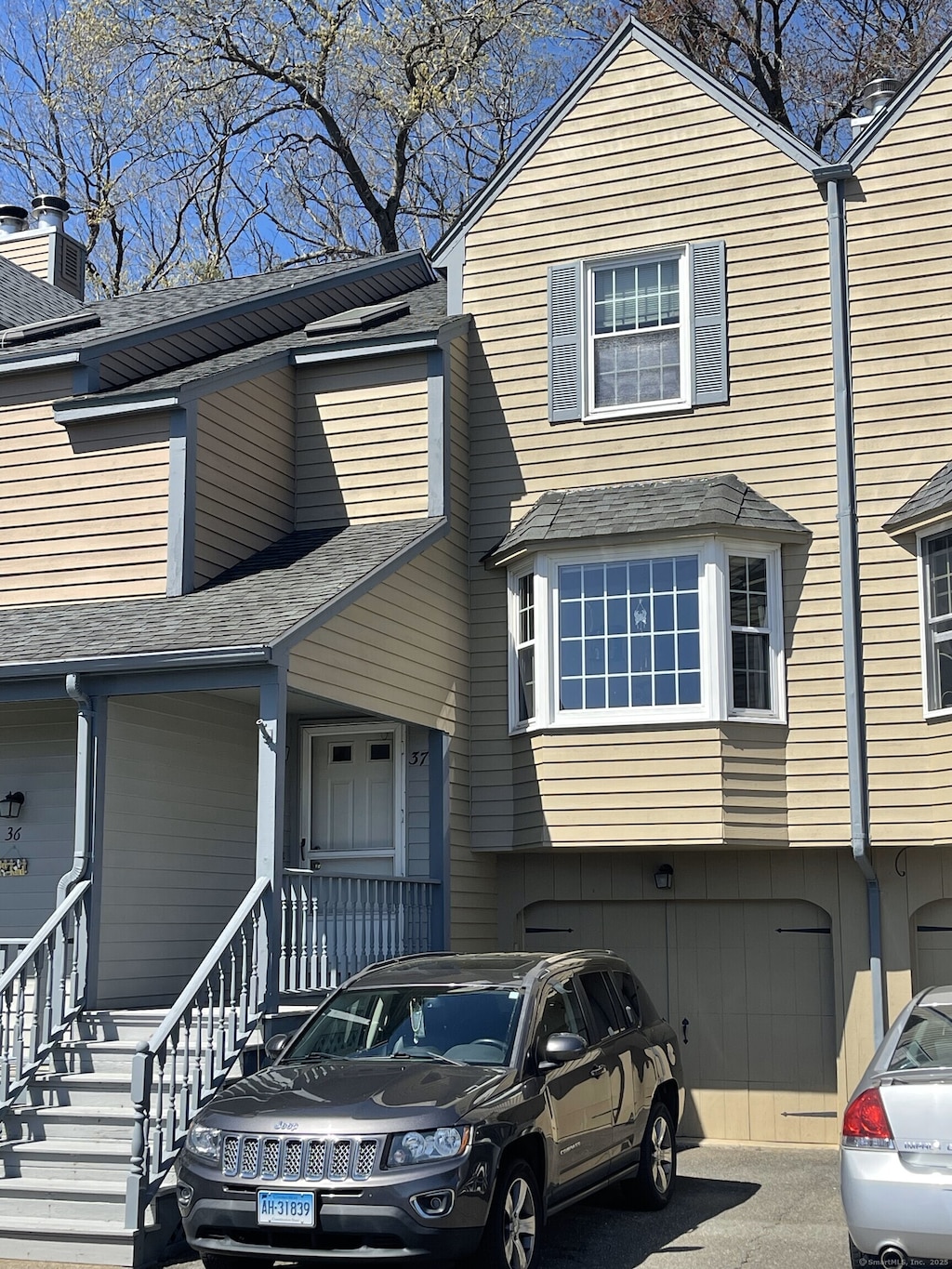 view of property featuring roof with shingles and a garage