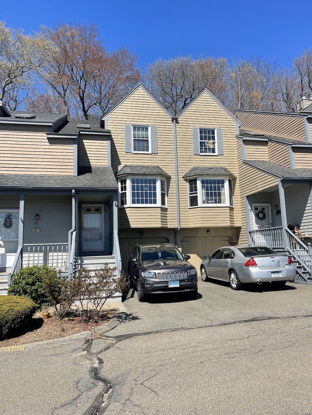 townhome / multi-family property with a shingled roof and driveway