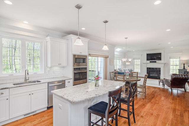 kitchen featuring a sink, appliances with stainless steel finishes, a wealth of natural light, and open floor plan