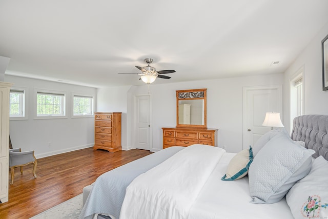 bedroom featuring baseboards, ceiling fan, and wood finished floors
