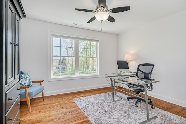 office area featuring baseboards, ceiling fan, light wood-style flooring, and visible vents