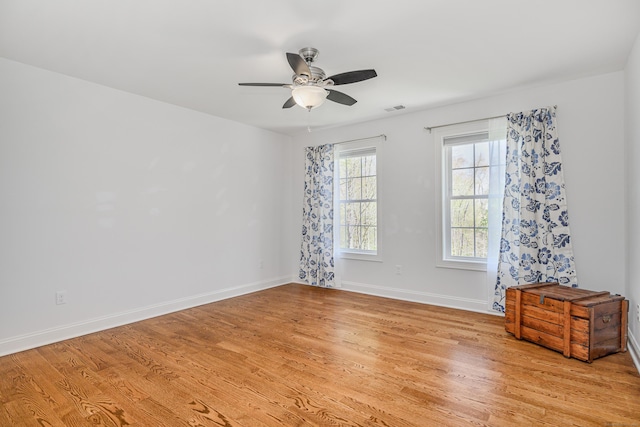 empty room with a ceiling fan, baseboards, visible vents, and light wood-style flooring
