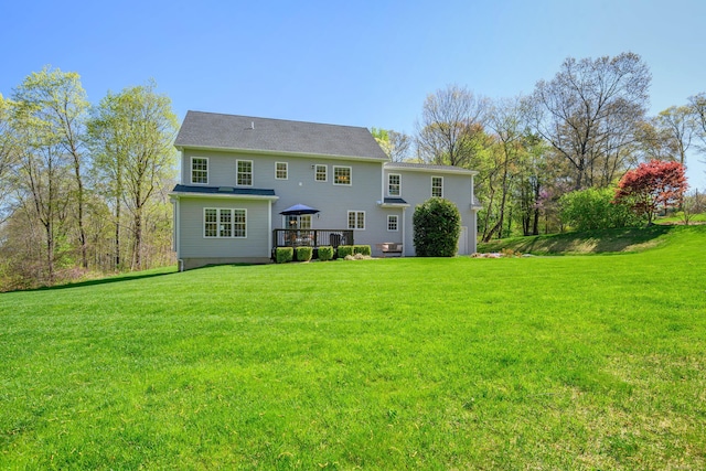 rear view of house with a lawn and a wooden deck