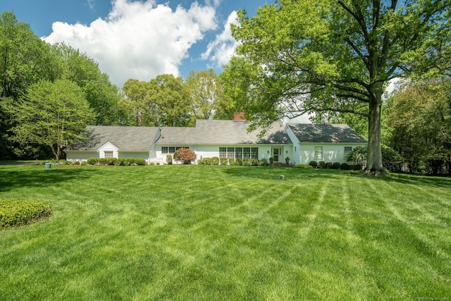 view of front of house with a front yard and a chimney
