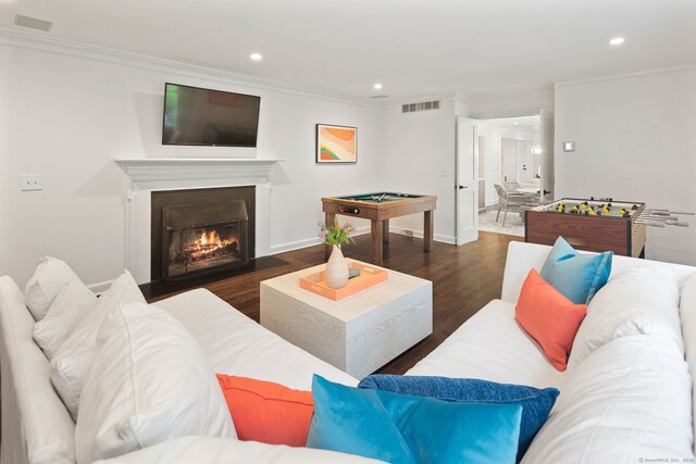 living area featuring ornamental molding, recessed lighting, wood finished floors, a fireplace with flush hearth, and baseboards