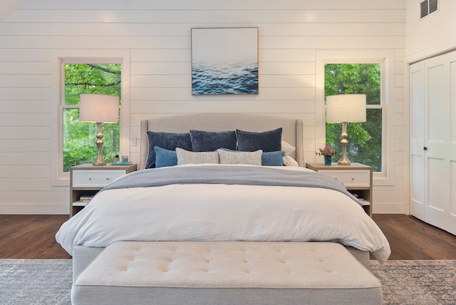 bedroom featuring wood finished floors and wood walls