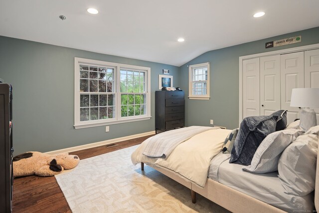 bedroom with wood finished floors, recessed lighting, vaulted ceiling, a closet, and baseboards