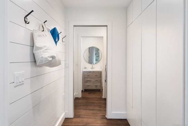 corridor featuring dark wood-style flooring and a sink
