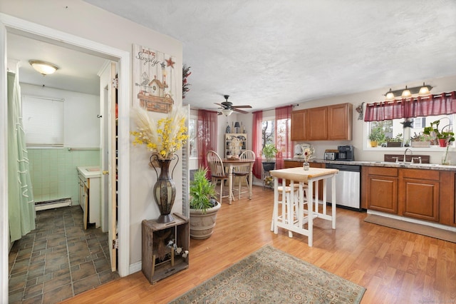 200 Mechanic St, Killingly, CT 06239 - kitchen featuring stainless steel dishwasher, a baseboard heating unit, healthy amount of natural light, a ceiling fan, and a textured ceiling