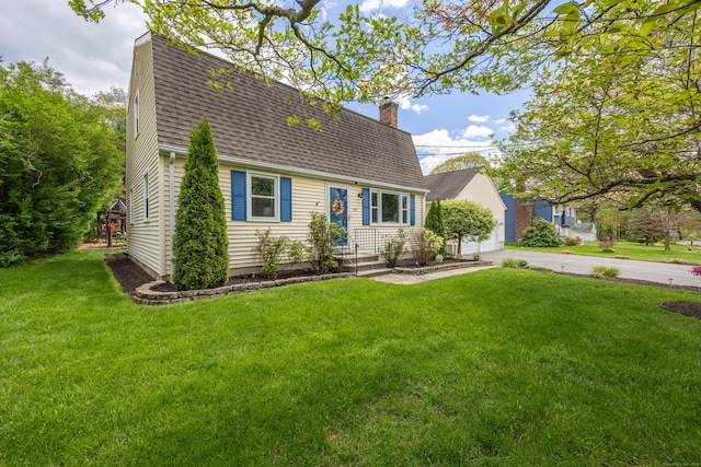 colonial inspired home featuring a shingled roof, a chimney, a front yard, and a gambrel roof