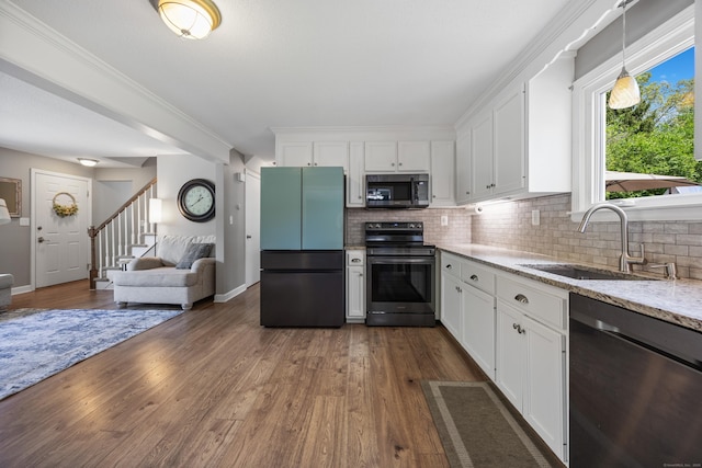 kitchen featuring appliances with stainless steel finishes, a sink, light stone countertops, and tasteful backsplash
