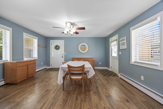 dining space featuring a baseboard heating unit, a ceiling fan, and dark wood-style flooring