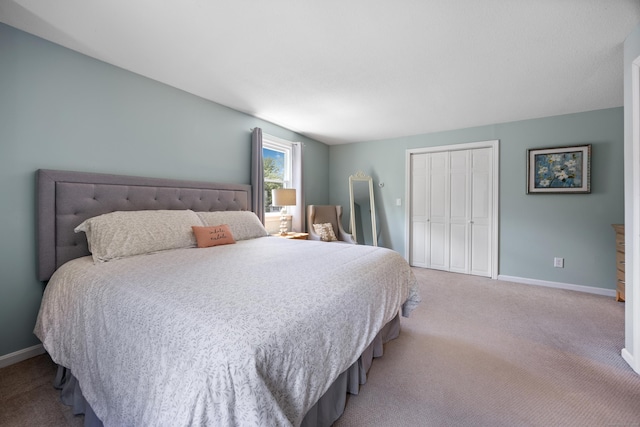 carpeted bedroom featuring a closet and baseboards