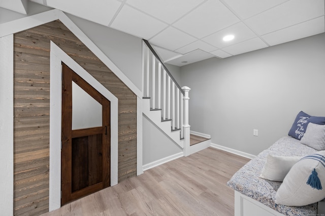 living area with light wood-style flooring, stairs, baseboards, recessed lighting, and a drop ceiling