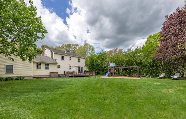view of green lawn featuring a playground, a deck, and central air condition unit