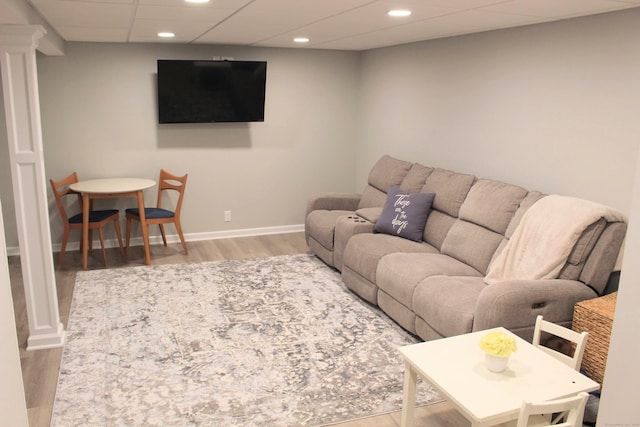 living area featuring wood finished floors, baseboards, recessed lighting, and a paneled ceiling