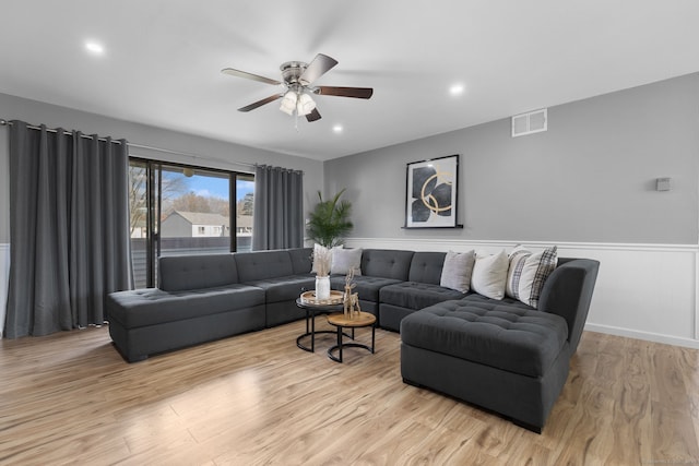 living area with recessed lighting, wood finished floors, wainscoting, ceiling fan, and visible vents