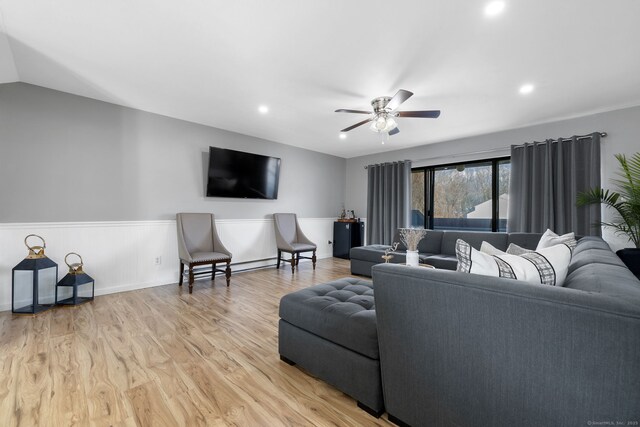 living area featuring recessed lighting, a ceiling fan, wainscoting, and light wood-type flooring