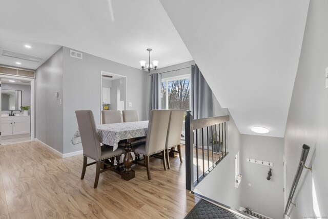dining room featuring a notable chandelier, visible vents, light wood-style flooring, and baseboards