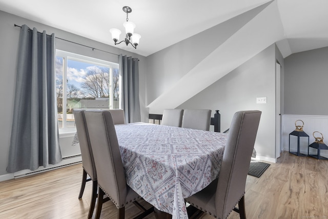 dining area featuring a baseboard radiator, light wood-style flooring, a wainscoted wall, and a notable chandelier