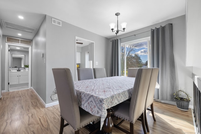 dining room featuring light wood finished floors, recessed lighting, an inviting chandelier, visible vents, and baseboards