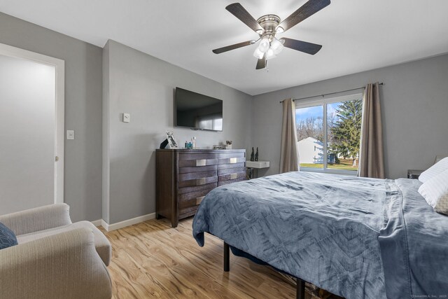 bedroom featuring a ceiling fan, light wood-style flooring, and baseboards