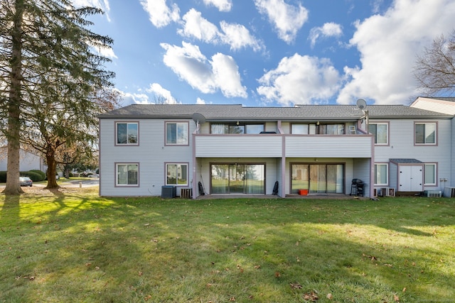 back of property with a lawn and a balcony