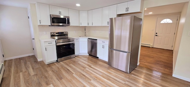 kitchen featuring light countertops, stainless steel appliances, baseboard heating, and light wood-style floors