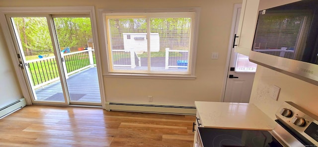 doorway to outside featuring a baseboard radiator and light wood finished floors