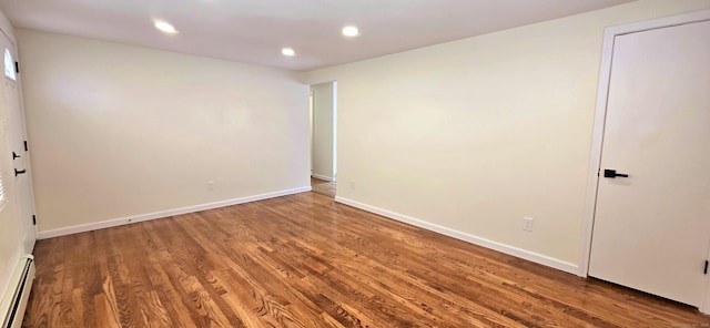 empty room with recessed lighting, baseboards, a baseboard heating unit, and wood finished floors