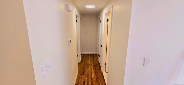 corridor with baseboards and wood finished floors