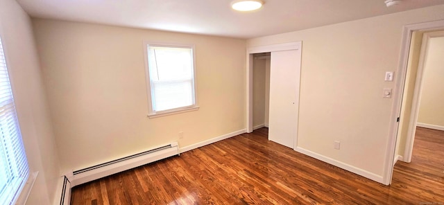 unfurnished bedroom featuring a closet, baseboards, dark wood finished floors, and a baseboard radiator
