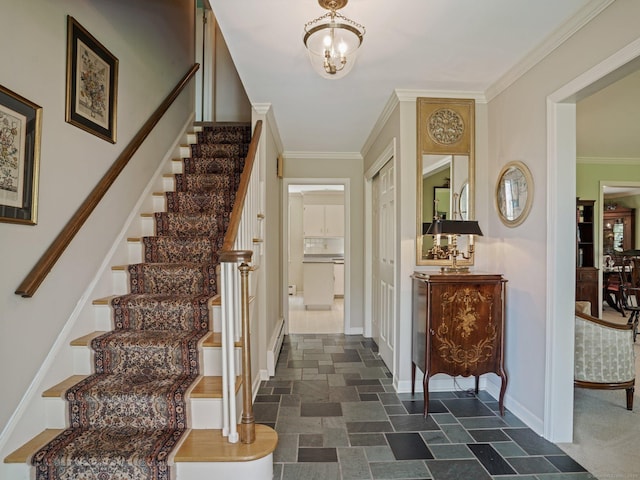 foyer entrance with baseboard heating, stairway, stone tile flooring, baseboards, and crown molding