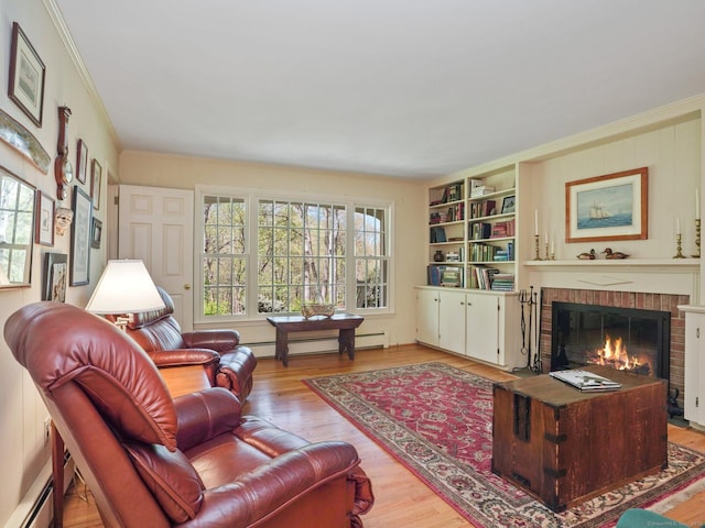 living room with a baseboard heating unit, a brick fireplace, wood finished floors, and crown molding
