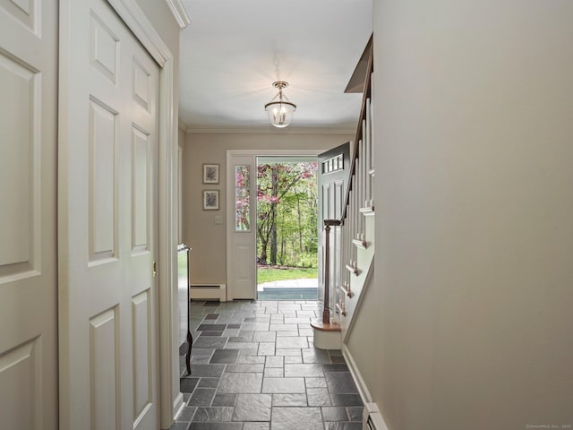 entryway with stone tile flooring, a baseboard heating unit, baseboards, crown molding, and a chandelier