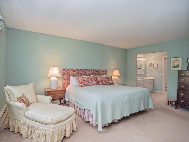 bedroom with light colored carpet, ensuite bathroom, baseboards, and a baseboard heating unit