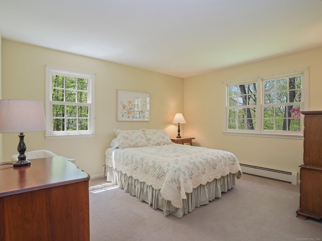 bedroom with baseboard heating, light carpet, multiple windows, and baseboards